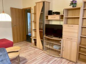 a living room with a tv and some shelves at Nordsee 406 in Wangerooge