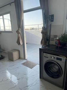 a kitchen with a washing machine in a room at Appartement- Terrasse sublime in El Jadida