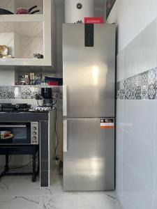 a stainless steel refrigerator in a kitchen next to a stove at Appartement- Terrasse sublime in El Jadida