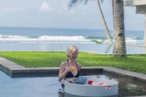 uma mulher numa piscina com uma tigela de comida em Kelapa Retreat & Spa em Pulukan