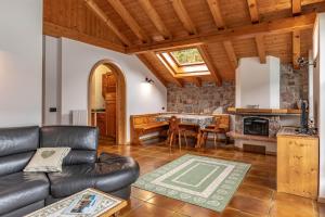 ein Wohnzimmer mit einem Sofa und einem Tisch in der Unterkunft Lo scrigno del lago Molveno Trento in Molveno