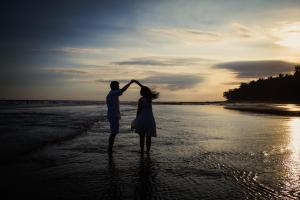 a man and a woman standing on the beach at Kelapa Retreat & Spa in Pulukan