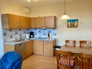a kitchen with wooden cabinets and a table with chairs at Nordsee 411 in Wangerooge