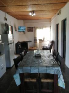 a dining room with a table and a kitchen at Cabaña Jacarandá in Villa Serrana