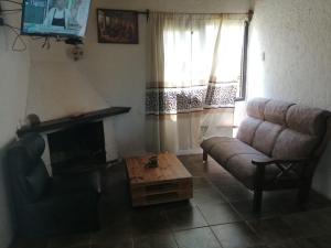sala de estar con sofá y mesa de centro en Cabaña Jacarandá, en Villa Serrana