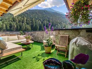 a patio with a couch and chairs on the grass at DMG - 'The Luxury Penthouse' in Fulpmes