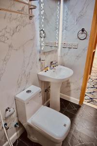 Un baño con un inodoro blanco y un lavabo. en Kayan Al Raya Hotel Makkah by Moro, en La Meca