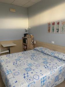 ein Schlafzimmer mit einem Bett mit einer blau-weißen Decke in der Unterkunft Il Chiesino in Pontedera