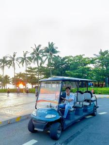 Een man die in een golfkar rijdt. bij Agarwood Boutique House Phu Quoc - Free Kitchen in Phu Quoc