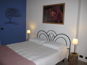 ディアーノ・ダルバにあるNew Casa Arcobaleno apartments-Room holiday homeの白いベッドと壁に絵画が飾られたベッドルーム1室
