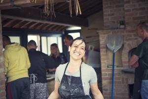 Una mujer en un delantal parada en una cocina en Glamping Diacceroni, en Villamagna