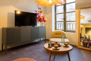 a living room with a television and a coffee table at La Villa Serra - Appartements in Agen