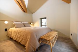 um quarto com uma cama grande e uma cadeira em La Villa Serra - Appartements em Agen