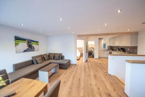 a large living room with a couch and a kitchen at Haus an der Haslach in Lenzkirch