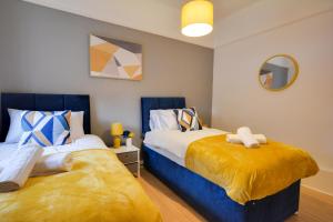 um quarto com 2 camas e um espelho em Luxurious and Roomy 2-BD Apartment - Free Parking em Wallasey