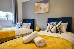 1 dormitorio con 2 camas de color amarillo y azul en Airey Spacious 2BD Flat - Free Parking Fast Wifi, en Wallasey