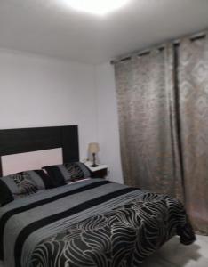 a bedroom with a black and white bed and a window at Marbella apartamento en Malaga in Málaga