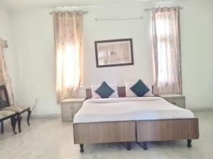 a bedroom with a large bed with blue pillows at JHALANA RETREAT RESORT in Jaipur