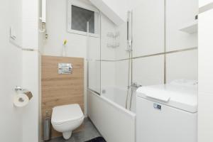 a white bathroom with a toilet and a sink at Rajska Łodź One Bedroom & Balcony by Renters in Łódź