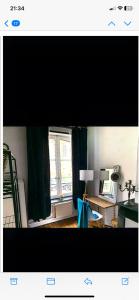 uma sala de estar com uma janela e uma secretária com um candeeiro em Apparemment Cosy Cathédrale em Metz