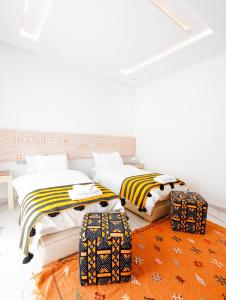 a bedroom with two beds and two suitcases at Villa Africa in Essaouira +38 photos