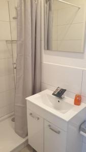 a bathroom with a sink and a shower with a mirror at Ferienwohnung in Bochum