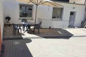 un patio con mesa, sillas y sombrilla en Ferienwohnung en Bochum