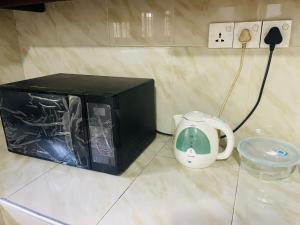 a microwave sitting on a counter next to a toaster at Sri Mali Holiday Home in Pelena