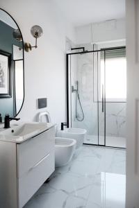 a white bathroom with two sinks and a shower at ComeCasa Città Studi Terraced Apartment in Milan