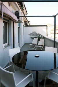 a balcony with white chairs and a table on a balcony at ComeCasa Città Studi Terraced Apartment in Milan