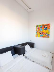 Villa Africa في الصويرة: سريرين في غرفة مع لوحة على الحائط