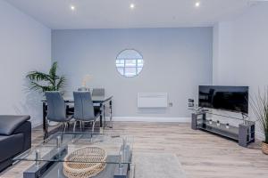 a living room with a dining table and a tv at Stunning Three Bedroom Townhouse In The Jewellery Quarter, Birmingham City Centre Sleeps 5- Free Parking in Birmingham