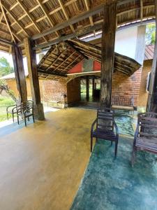 pusty pokój z dwoma ławkami i ceglaną ścianą w obiekcie Ralapela Eco Resort w Tangalli