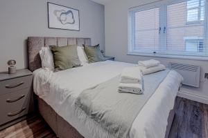 - une chambre avec un grand lit et des serviettes dans l'établissement Stunning Three Bedroom Townhouse In The Jewellery Quarter, Birmingham City Centre Sleeps 5- Free Parking, à Birmingham