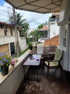 um pátio com uma mesa e cadeiras numa varanda em Sarojeni Apartments em Negombo