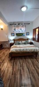 ein Schlafzimmer mit einem großen Bett und Holzboden in der Unterkunft Vythee Residence in Chemin Grenier
