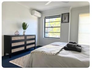 a bedroom with a bed and a dresser and a window at Balgowlah as home in Sydney