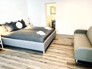 ein Schlafzimmer mit einem Bett und einem Sofa in der Unterkunft Modern designed, luxury mountain view Apartment in Kandersteg