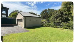 a garage in a yard with a grass field at Balgowlah as home in Sydney