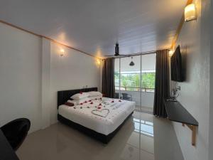 une chambre avec un lit et une grande fenêtre dans l'établissement Dacha Thoddoo White Sand, à Thoddoo