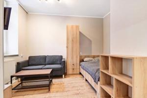 a bedroom with a bed and a couch and a table at Tiny and cosy studio only 4 you in Katowice