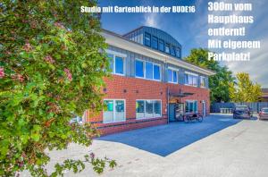 诺登Stadthotel-Garni Smutje的前面有停车位的砖砌建筑