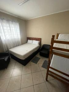 Garden Hostel - Santana في ساو باولو: غرفة نوم مع سرير وسرير بطابقين