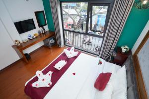 Un dormitorio con una cama blanca con dos conejos. en NT Elysian hotel en Hanoi