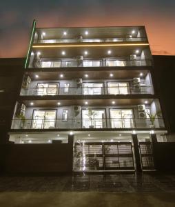 wysoki budynek z oświetleniem w nocy w obiekcie Limewood Stay Diamond 2BHK & Studio Huda City Centre & FORTIS w mieście Gurgaon