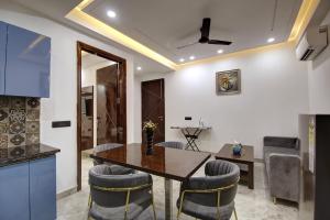kuchnia i jadalnia ze stołem i krzesłami w obiekcie Limewood Stay Diamond 2BHK & Studio Huda City Centre & FORTIS w mieście Gurgaon