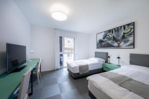 a room with two beds and a desk with a computer at "The Freddie Mercury" Hotel in Montreux