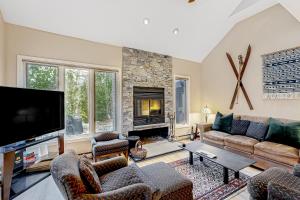 a living room with a couch and a tv at Forest Hideaway in Waterville Valley