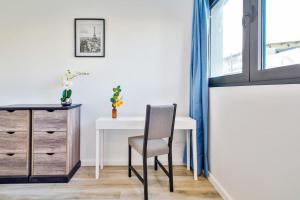 a desk and a chair in a room with a window at Studio Design Près du Metro in Montrouge