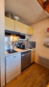 cocina con fregadero y fogones horno superior en Apartment for 6 people in the heart of Valberg resort en Valberg